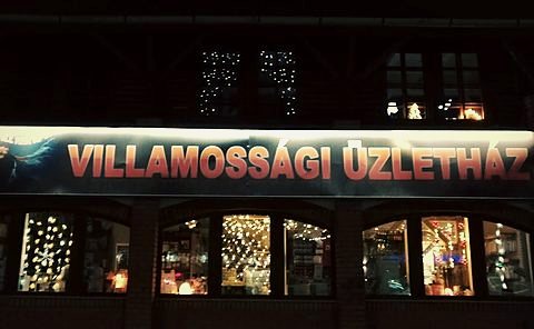 A Rockvillker üzletház homlokzata este, kivilágított cégtáblával és kirakatokkal.