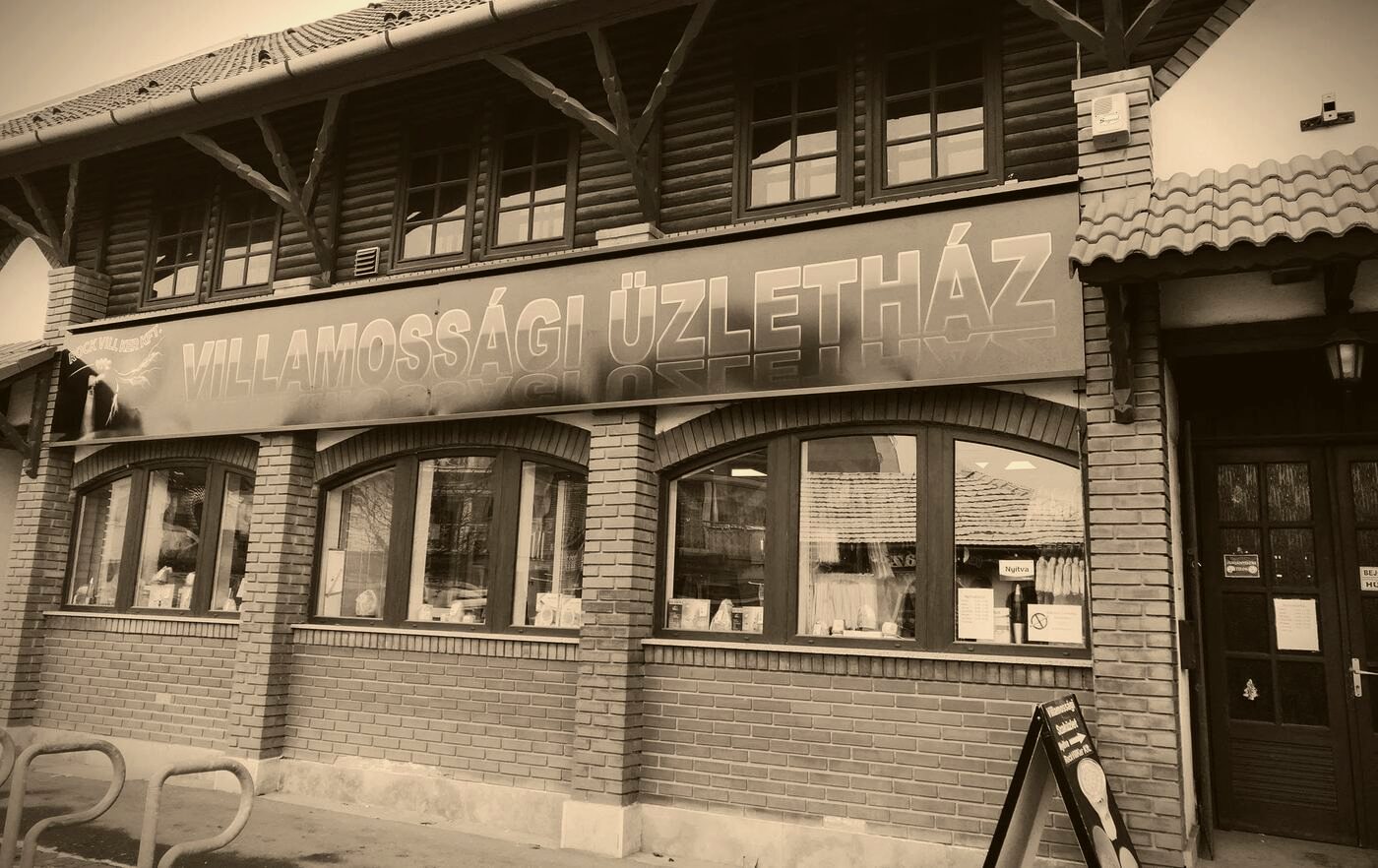 A Rockvillker üzletház téglahomlokzata nappal, nagy Villamossági Üzletház felirattal a bejárat felett.